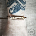 bracelet en bois gravé « Namasté », porté au poignet, artisanat et matière bois
