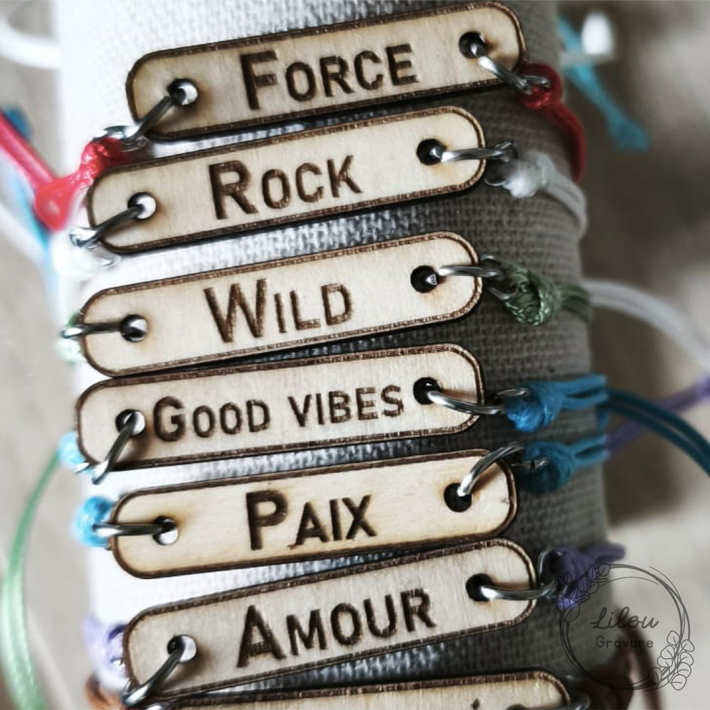 gros plan sur des plaques en bois gravées avec des mots variés, matière bois et gravure laser